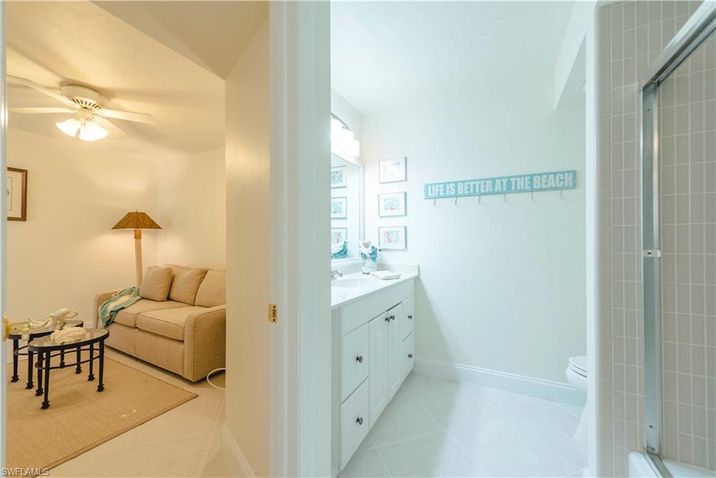 3107 Riviera Drive, Unit A202 Naples, FL 34103 - Photo 18 of 25 a en suite bathroom with a granite countertop sink and a mirror