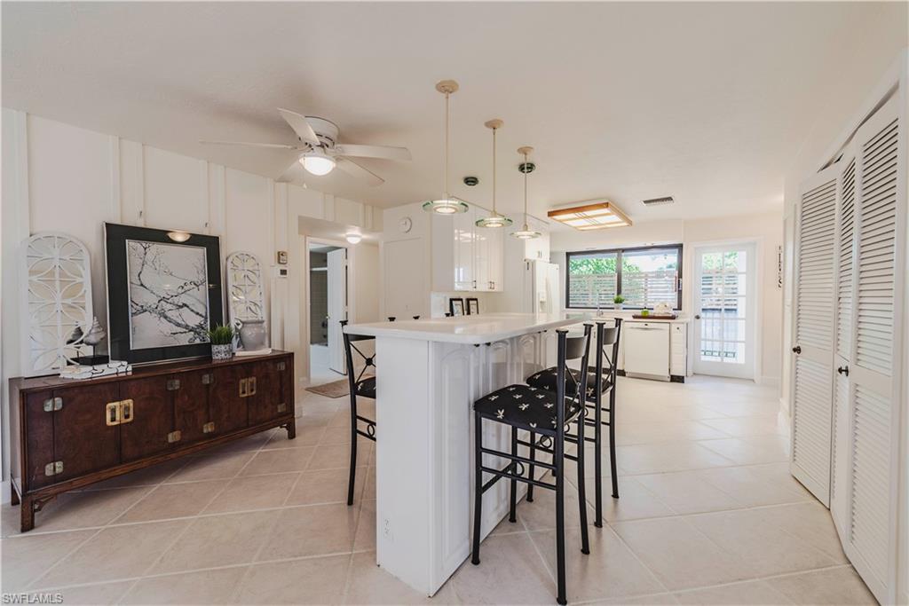 3107 Riviera Drive, Unit A202 Naples, FL 34103 - Photo 2 of 25 a kitchen with a table and chairs in it