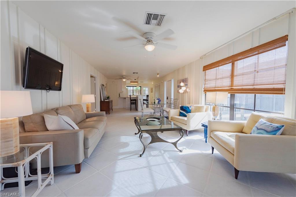 3107 Riviera Drive, Unit A202 Naples, FL 34103 - Photo 8 of 25 a living room with furniture and a flat screen tv