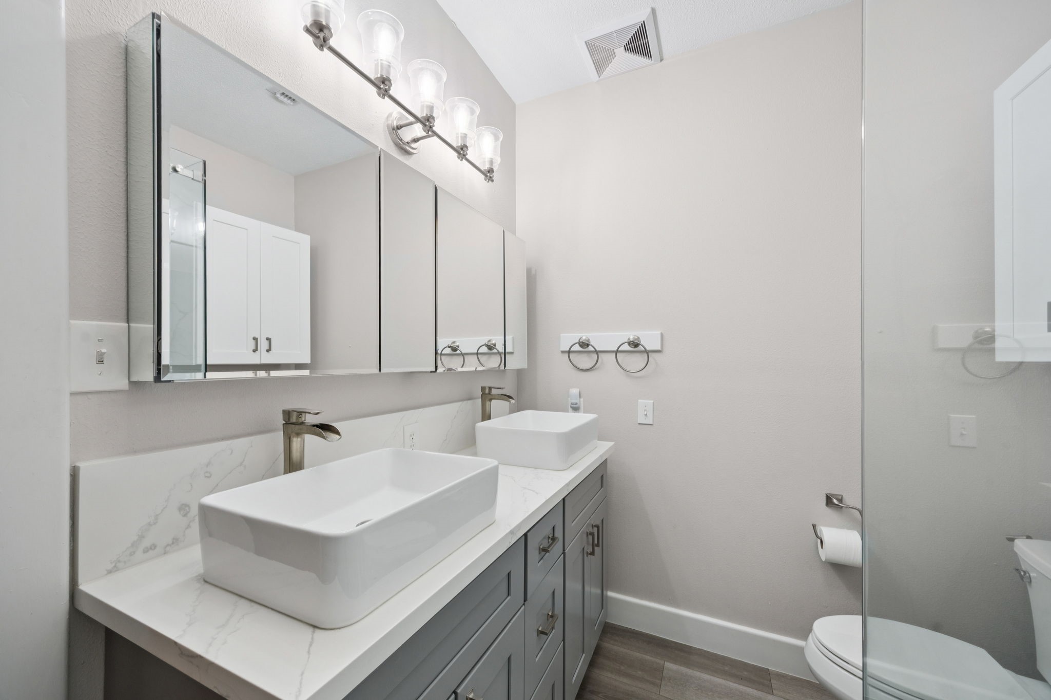 500 River Road, Unit 106 Montgomery, TX 77356 - Photo 18 of 32 Primary bathroom includes quartz countertops, dual sinks, large mirrored medicine cabinets and multiple pull-out drawers for lots of storage.