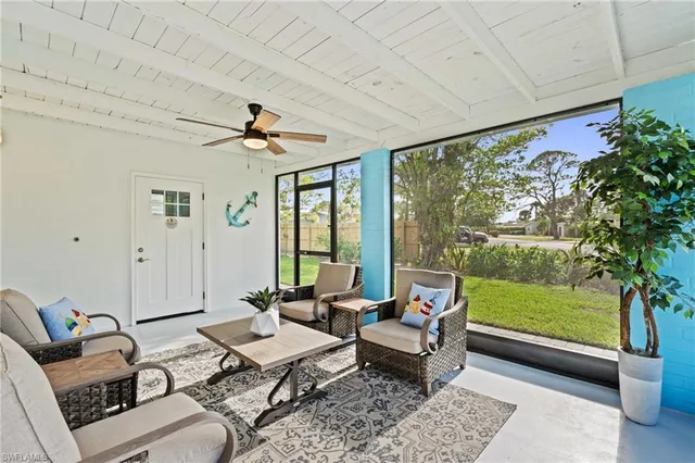 a living room with patio furniture and a floor to ceiling window