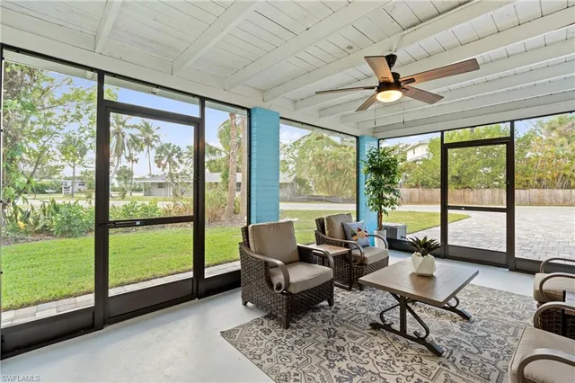 a living room with furniture and a floor to ceiling window