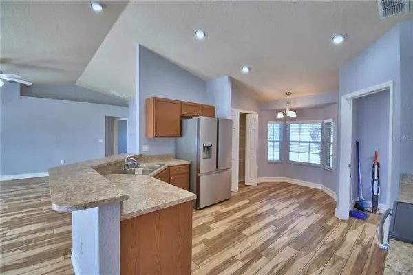 a view of kitchen with stainless steel appliances granite countertop cabinets and wooden floor