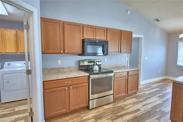 a kitchen with stainless steel appliances granite countertop a refrigerator and a stove top oven