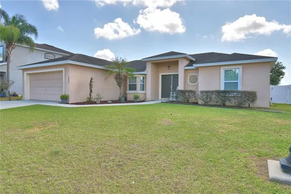 a front view of house with yard and garage