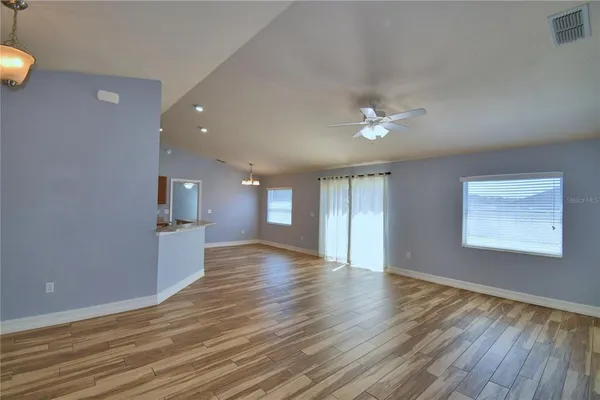 a kitchen with stainless steel appliances granite countertop a stove top oven a sink dishwasher and a refrigerator with wooden floor