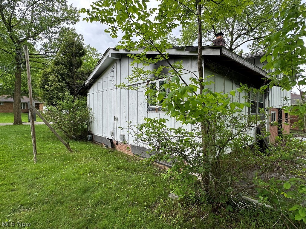 5319 Fairtree Road Bedford Heights, OH 44146 - Photo 6 of 27 White siding exterior with a brick foundation accent, featuring multiple windows and a chimney structure
