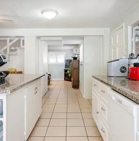 a large white kitchen with stainless steel appliances granite countertop a sink and cabinets