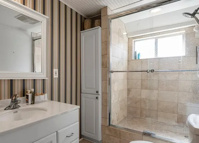 a bathroom with a sink mirror and shower