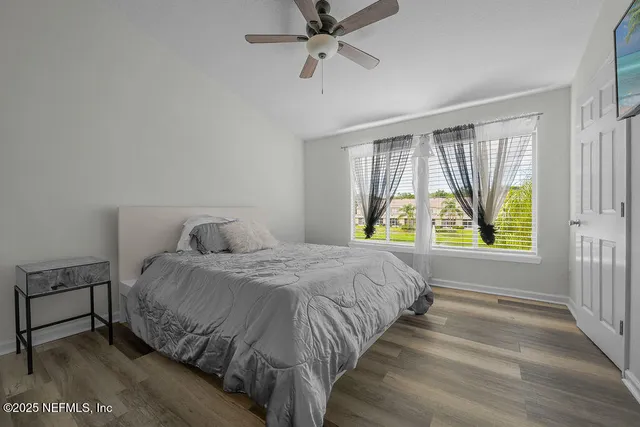 a bedroom with a bed and a ceiling fan