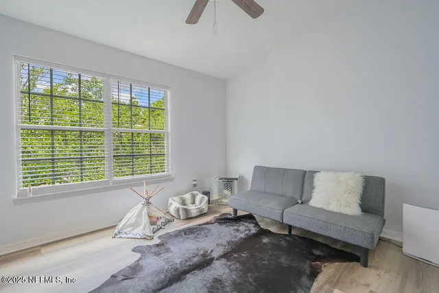 a bedroom with a bed and a chandelier fan