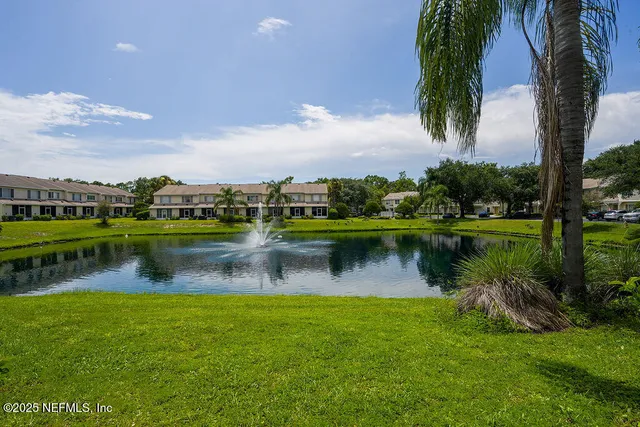 an aerial view of a house with a yard and lake view