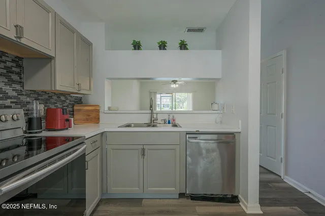 a kitchen with a sink cabinets and stainless steel appliances