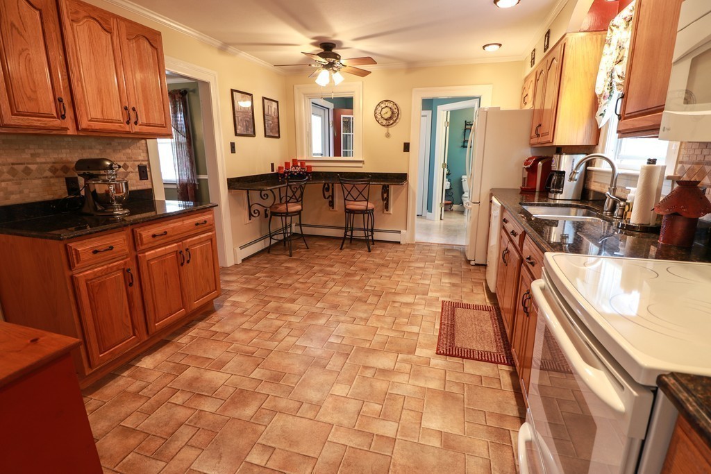 55 Mason Road Dudley, MA 01571 - Photo 3 of 19 a large kitchen with stainless steel appliances a stove a sink dishwasher and cabinets with wooden floor