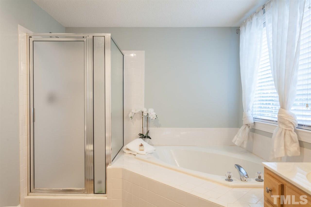 2337 Florida Court Raleigh, NC 27615 - Photo 15 of 25 a bathroom with a tub sink and mirror