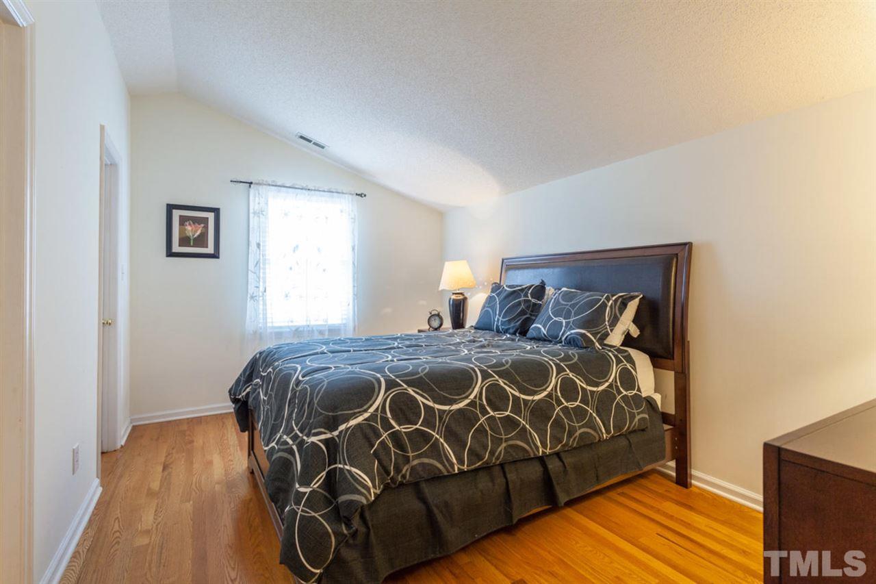 2337 Florida Court Raleigh, NC 27615 - Photo 18 of 25 a bed sitting in a bedroom next to a window with wooden floor