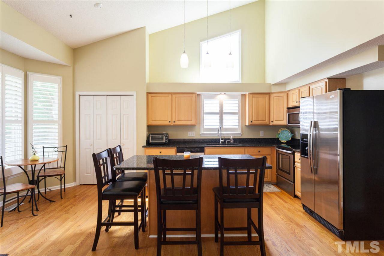 2337 Florida Court Raleigh, NC 27615 - Photo 6 of 25 a kitchen with stainless steel appliances a dining table chairs and a refrigerator