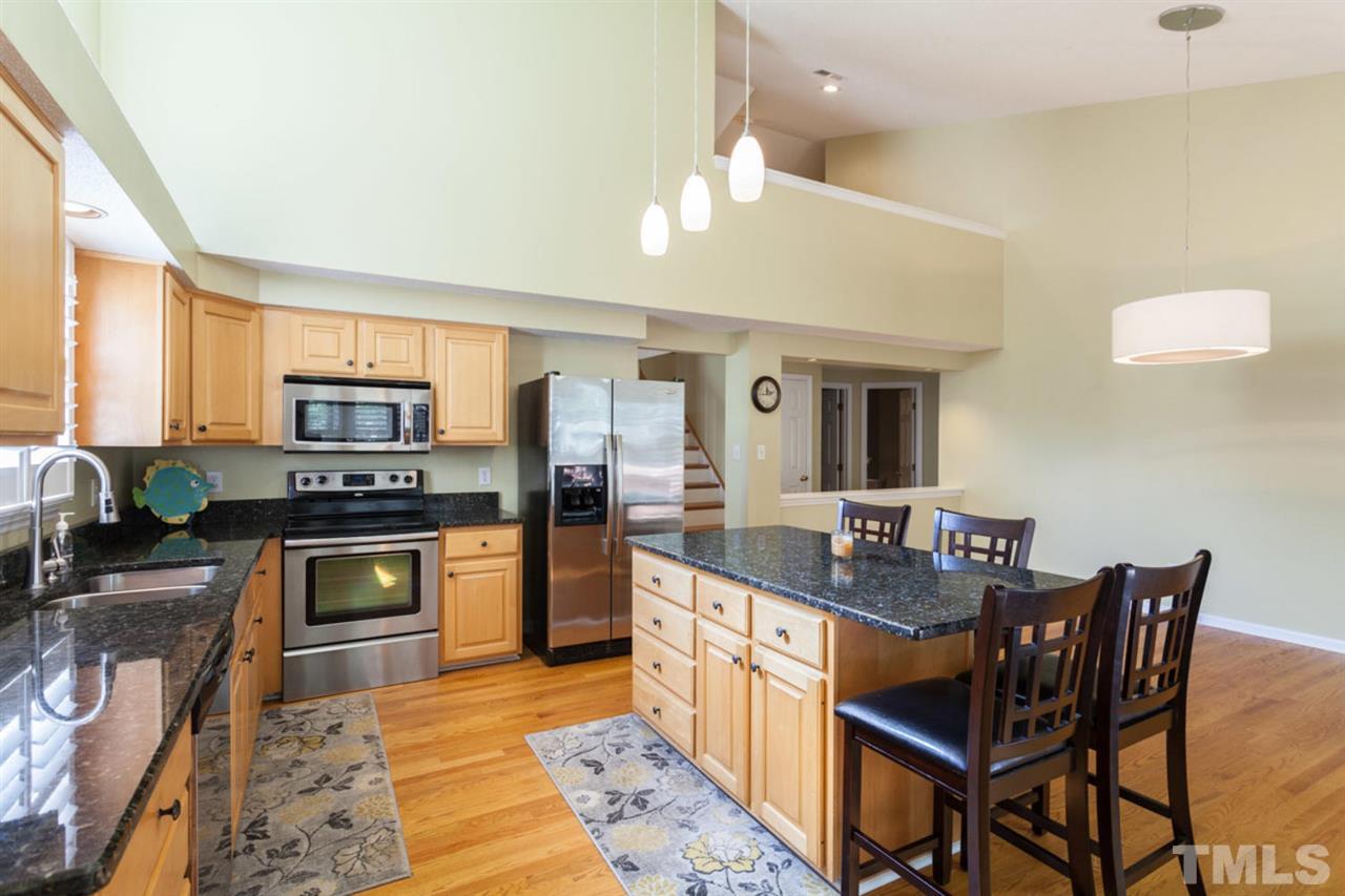 2337 Florida Court Raleigh, NC 27615 - Photo 8 of 25 a kitchen with stainless steel appliances granite countertop a stove top oven a sink dishwasher a dining table and chairs with wooden floor