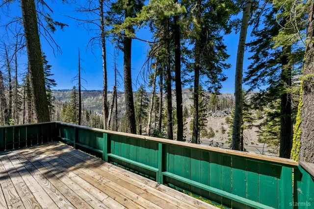 a view of balcony with wooden floor and fence