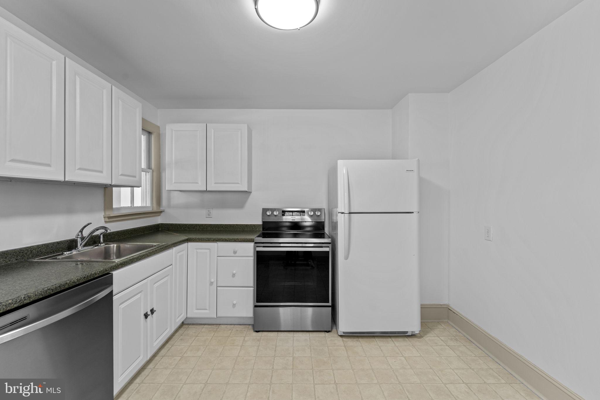 216 Walnut Street Berryville, VA 22611 - Photo 22 of 36 a kitchen with white cabinets white stainless steel appliances and sink