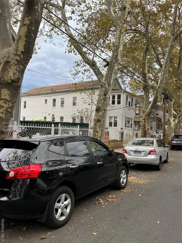 a car parked in front of a white house