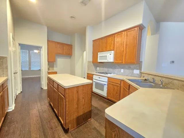 a kitchen with a stove a sink a refrigerator and a microwave oven