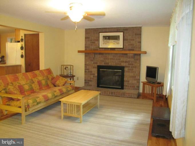 Living room with wood flooring,and gas fireplace.