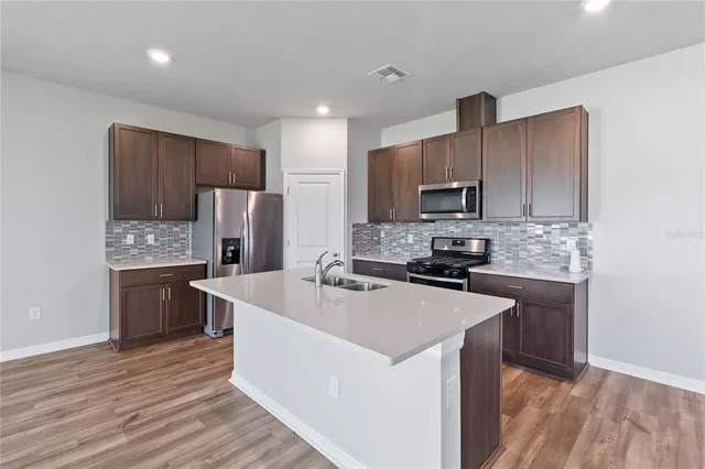 a kitchen with a sink cabinets and wooden floor
