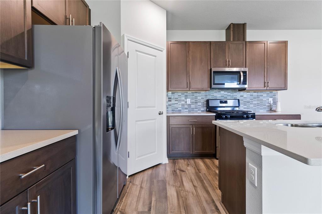 5617 Bungalow Grove Court Palmetto, FL 34221 - Photo 12 of 31 a kitchen with a refrigerator sink and white cabinets