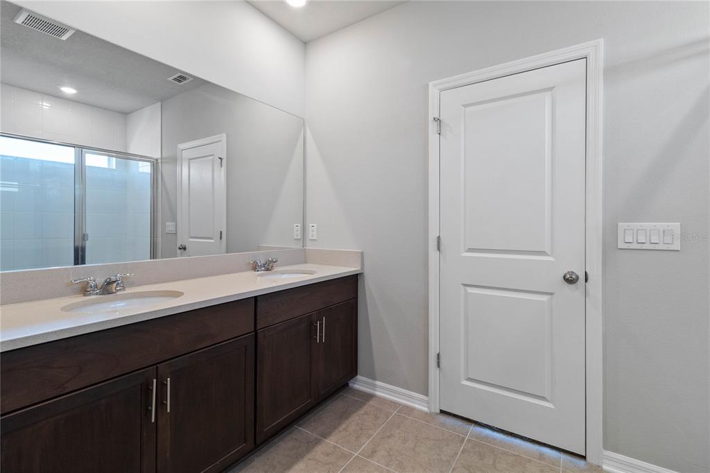 5617 Bungalow Grove Court Palmetto, FL 34221 - Photo 23 of 31 a bathroom with a double vanity sink and a mirror