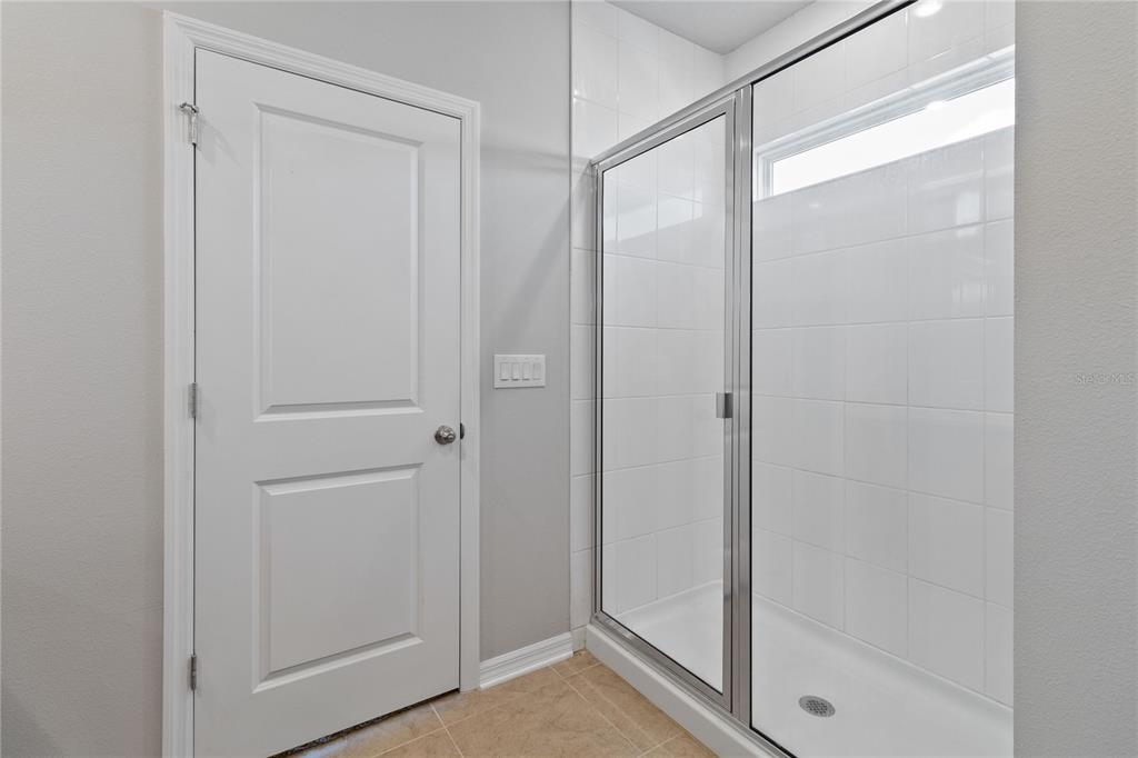 5617 Bungalow Grove Court Palmetto, FL 34221 - Photo 25 of 31 a bathroom with a glass shower door