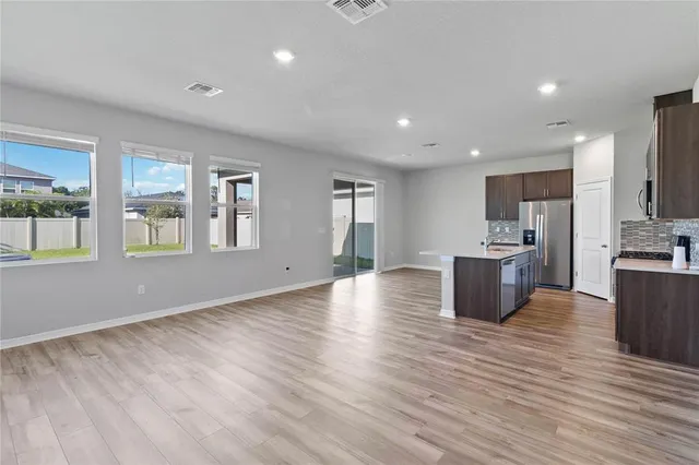 a kitchen with a refrigerator a stove top oven a sink and dishwasher with wooden floor