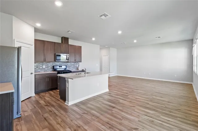 a kitchen with a refrigerator sink and white cabinets
