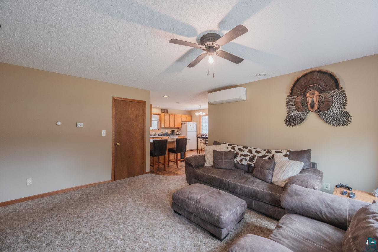 228 3rd Street Southeast Cook, MN 55723 - Photo 9 of 30 Spacious living area with carpet flooring and neutral wall tones