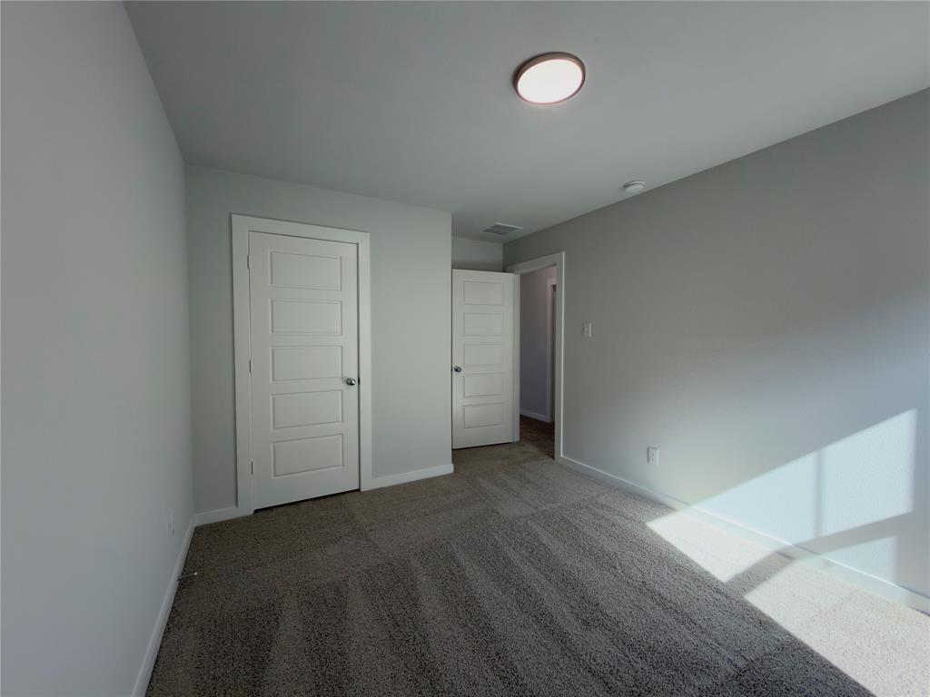 120 Millwood Road Lavon, TX 75166 - Photo 12 of 34 Spacious interior room with light gray walls, dark gray carpet, a contemporary flush-mount ceiling light, and white trim