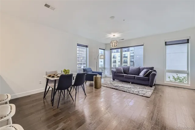 a living room with furniture a wooden floor and a window