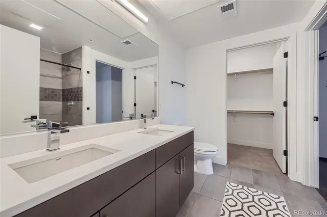 a bathroom with a double vanity sink mirror and toilet