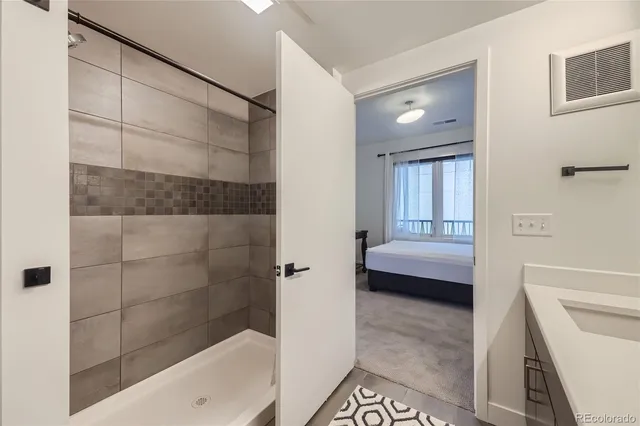 a bathroom with a tub shower and sink