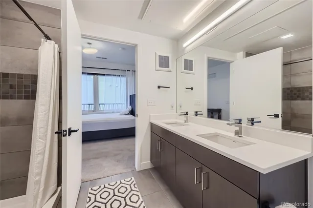 a bathroom with a double vanity sink mirror and shower