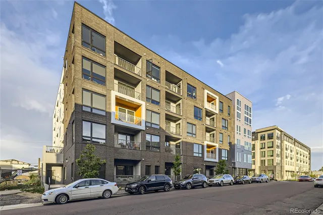 a couple of cars parked in front of a building