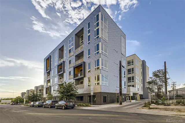 a city street with tall building and trees in the background