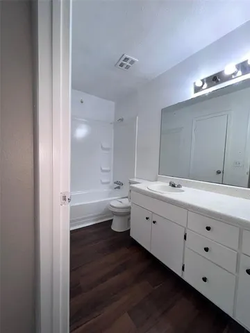 a bathroom with double vanity sink a mirror and a bathtub