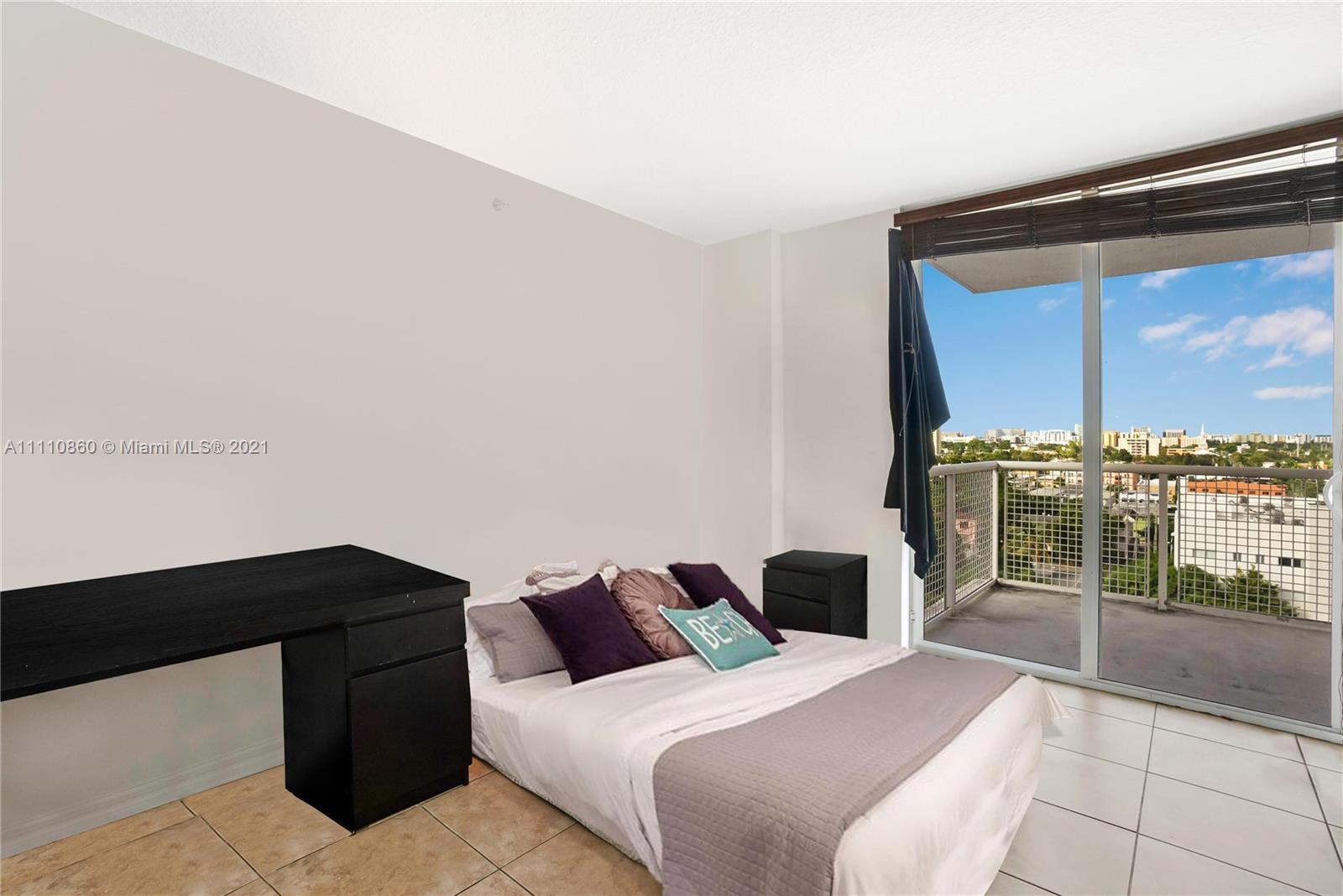 900 Southwest 8th Street, Unit 904 Miami, FL 33130 - Photo 4 of 12 a bedroom with a bed and glass window