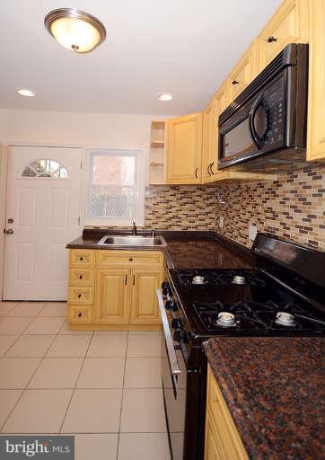 4305 Wakefield Road Baltimore, MD 21216 - Photo 2 of 25 a kitchen with a stove a sink and a microwave