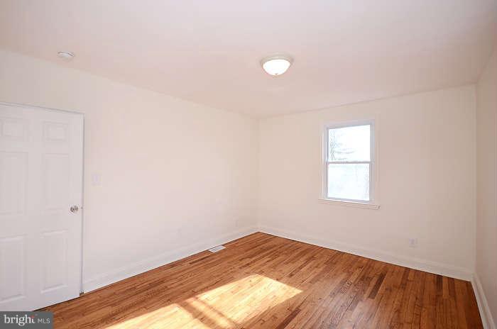 4305 Wakefield Road Baltimore, MD 21216 - Photo 12 of 25 a view of empty room with wooden floor and fan