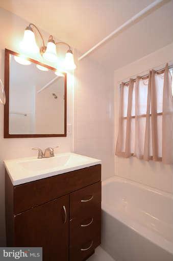 4305 Wakefield Road Baltimore, MD 21216 - Photo 15 of 25 a bathroom with a sink vanity tub and a mirror