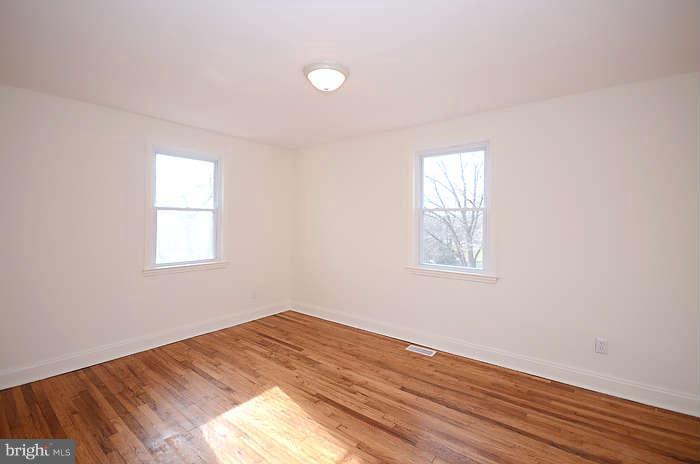 4305 Wakefield Road Baltimore, MD 21216 - Photo 17 of 25 an empty room with wooden floor and windows