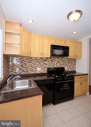 4305 Wakefield Road Baltimore, MD 21216 - Photo 4 of 25 a kitchen with granite countertop a sink stainless steel appliances and cabinets