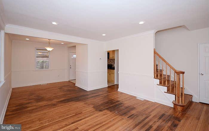 4305 Wakefield Road Baltimore, MD 21216 - Photo 5 of 25 a view of an empty room with wooden floor and stairs