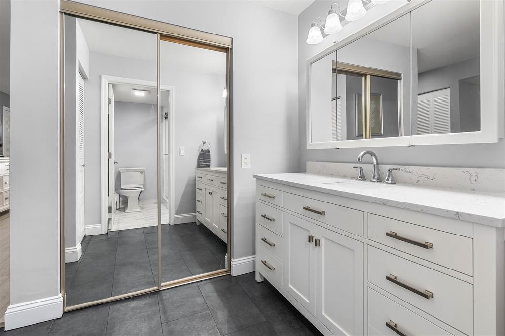 9286 Vista Del Lago, Unit E Boca Raton, FL 33428 - Photo 16 of 26 a spacious bathroom with a double vanity sink a mirror and a shower